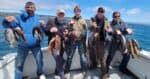 Group of anglers holding their catch on a boat in Santa Cruz Bay.