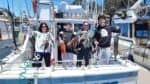 Group of anglers holding their catch on a boat at Santa Cruz marina.