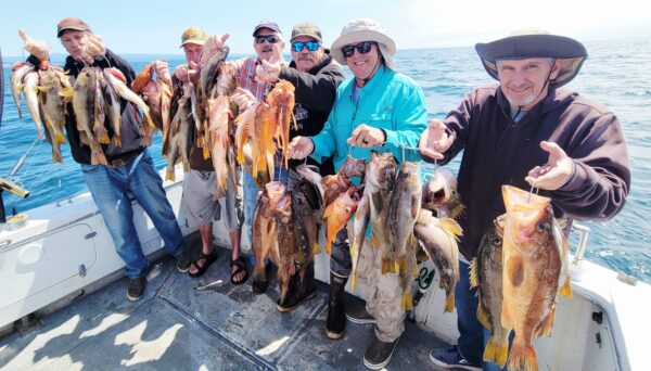 Group of anglers displaying their catch of fish on a boat in Santa Cruz.